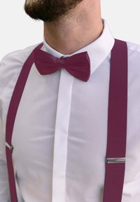 Weißes Hemd mit strukturierter Oberfläche, ausgestattet mit einer burgunderfarbenen Fliege und passenden Hosenträgern mit metallischen Clips. Einfaches, sauberes Design.