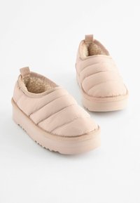Scarpe slip-on imbottite rosa con fodera in faux shearling, suola in gomma e dettagli cuciti sulla parte superiore; presentano un tassello sul retro.