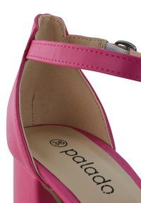 Rosa High-Heel-Sandalette mit glattem Synthetik-Obermaterial, Knöchelriemen, gepolsterter Innensohle und auffälligem Branding auf dem Fußbett.
