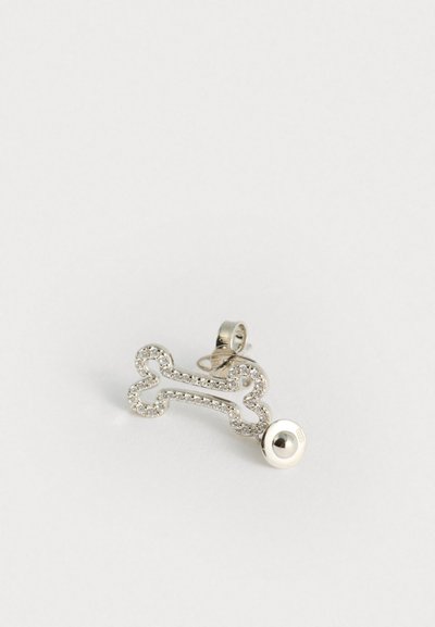 Pendente prateado em forma de osso, com strass transparentes que contornam a forma. Possui um laço para afixação e um detalhe redondo brilhante na extremidade.