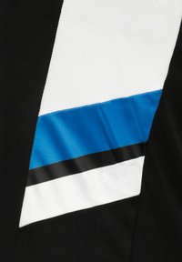 Primer plano de tela negra con un panel blanco diagonal que presenta rayas azules y delgadas líneas negras, mostrando textura y contraste de color.