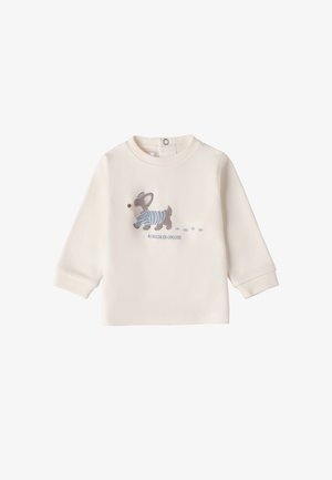 Camisa de manga larga color crema hecha de una tela suave, que presenta un divertido dibujo de un perro con una camisa a rayas azules y huellas de patas.