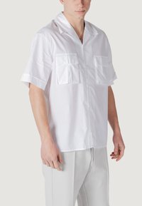 Witte kortekorte mouwen shirt van lichte stof met twee borstzakken, een geknipt kraag en een rechte zoom.