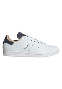 Valge nahast toss, millel on tekstureeritud tumesinine keel. Omab väikeseid perforatsioone, lameid valgeid paelu ja kummist tallat, millel on brändi logo.