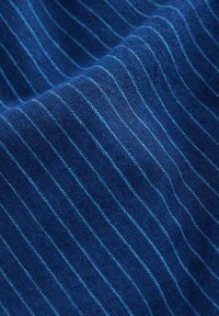 Tissu tissé en bleu profond avec de fines rayures bleu clair. Texture douce avec une finition lisse, présentant un motif uniforme tout au long.