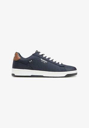 Baskets bleu marine avec une tige en tissu texturé, des lacets blancs, des accents en cuir marron au niveau du talon et une semelle en caoutchouc blanc avec une bonne adhérence.