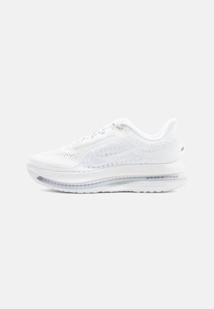 Balta sporta apavi ar elpojošu acu virsmu, teksturētu dizainu, mīkstinātu zoli un redzamu gaisa spilvenu papēdī.