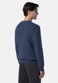 Jersey de punto azul marino con cuello redondo, tejido texturizado y dobladillo acanalado. Presenta mangas largas y un corte relajado.