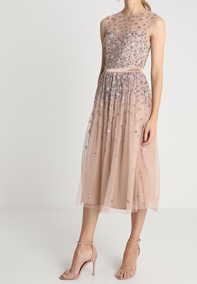 Un vestido sin mangas hasta la rodilla en suave tul de color rosa empolvado adornado con lentejuelas florales multicolores. Presenta un corsé ajustado y una falda fluida.
