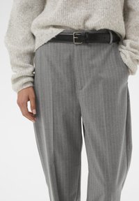 Pantaloni grigi a righe sottili realizzati in tessuto morbido, con vita alta, vestibilità comoda e una cintura in pelle nera con fibbia argentata.