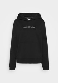 Sweat à capuche noir avec poche kangourou avant et logo blanc "CALVIN KLEIN JEANS" centré sur la poitrine, manches longues et capuche avec cordon.