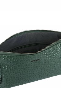 Borsa a pochette in pelle verde tessurizzata con chiusura a zip. Interno foderato in tessuto scuro con un motivo sottile. Accentuata da un dettaglio del logo.