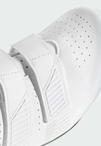 Weißer Fahrradsportschuh mit glattem synthetischem Obermaterial, perforiertem Design und zwei Klettverschlüssen. Mit strukturierten Akzenten an den Seiten.