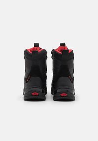 Black waterproof boots with red accents, textured panels, and reinforced heel. Features a pull tab and distinctive logo on the sole.