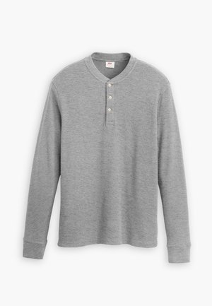 Chemise henley grise à manches longues en tissu côtelé, dotée d'une patte de boutonnage à trois boutons et d'un col rond avec une coupe légèrement ajustée.