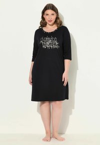 Czarna nocna koszula wykonana z miękkiego materiału, z rękawami o długości trzech czwartych i metalicznym napisem "Dobranoc" na przodzie.