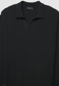 Schwarzer, gerippter Strickpullover mit V-Ausschnitt und langen Ärmeln. Das Etikett trägt die Aufschrift "CALLIOPE" und gibt Größe L an.