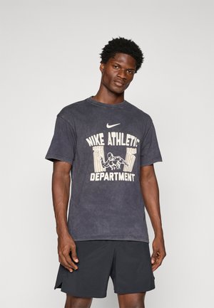 Mørk grå bomulds T-shirt med en stor, cremefarvet grafik med teksten "Nike Athletic Department" og en illustration af en muskuløs figur.