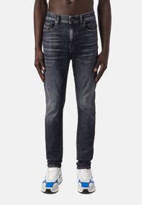 Mörkblå, slim-fit jeans i denim med en urtvättad finish. Har fem fickor, dragkedja och kontrasterande sömmar.