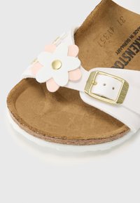 Vit sandal med en korkfotbädd, pryd med ett blommigt mönster i rosa och vitt, guldspännen och en strukturerad sula.