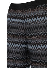 Strickleggings mit einem mehrfarbigen Zickzackmuster in Blau, Schwarz und Bronze sowie einem gerippten schwarzen Bund. Die strukturierte Oberfläche verleiht zusätzliche Tiefe.