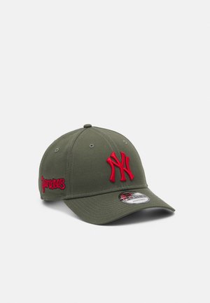 Casquette de baseball vert olive avec logo rouge des New York Yankees à l'avant et "Yankees" brodé sur le côté, présentée sur fond blanc.