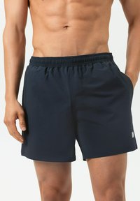 Shorts de bain bleu marine avec une ceinture élastique, un tissu texturé et des poches latérales. Le tissu présente un motif subtil. Ajustement réglable.