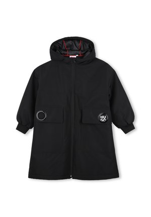 Manteau noir à capuche avec fermeture éclair à l'avant, deux grandes poches avec des détails ronds, et des poignets élastiques aux manches longues.
