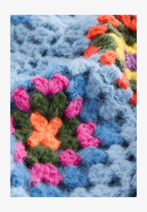 Häkeldecke mit lebhaften hexagonalen Mustern aus pinkem, orangefarbenem, grünem und blauen Garn. Weiche Textur mit flauschigen Faserdetails.