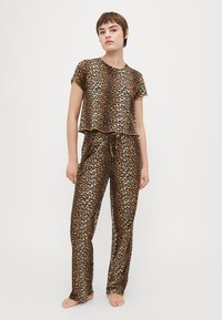 Set de pijama cu imprimeu de leopard, compus dintr-un top cu mâneci scurte și decolteu rotund, și pantaloni cu talie ajustabilă, realizat dintr-un material moale și fin.
