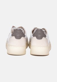 Sneakers bianchi in pelle con dettagli in suede beige, suola chunky color crema e targhette sul tallone grigie con marchio in rilievo.