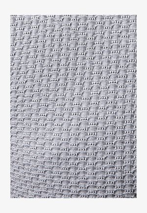 Tejido gris tejido que presenta un patrón texturizado de pequeños óvalos y hexágonos repetidos, proporcionando una superficie táctil visible.