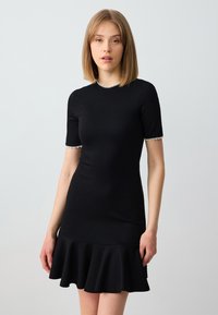 Czarna sukienka krótko-sleeve z dopasowanym korpusem, rozkloszowanym dołem oraz wykończoną perłami dekoltem i mankietami, wykonana z elastycznego materiału.