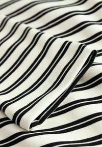 Țesătură în dungi alb-negru, cu o textură netedă. Prezintă dungi orizontale uniforme, bine distanțate și o margine pliată. Potrivită pentru îmbrăcăminte.