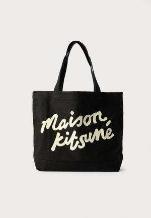 Juodas drobinių maišas su trumpomis rankenėlėmis, ant priekinės pusės ryškiai išryškintas baltas kursyvu parašytas tekstas "Maison Kitsuné".