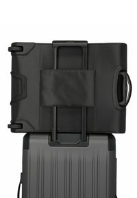 Black fabric suitcase with a retractable handle, stacked on a gray, hard-shell suitcase featuring vertical ridges and a side handle.