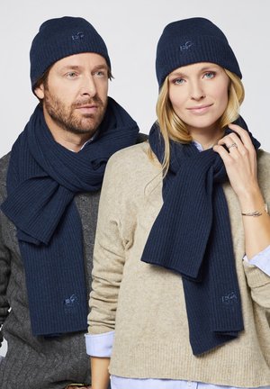 Navy ribbed knit beanie and scarf set, featuring embroidered logo detail. Beanie fits snugly, while scarf is long and textured.