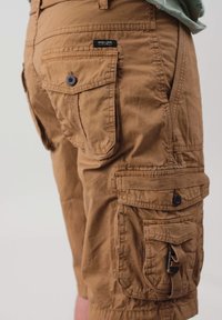 Shorts cargo marron en tissu léger, dotés de plusieurs poches, de fermetures à bouton et d'une coupe décontractée et ample.