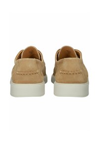 Kein beige suede slip-on kengät, joissa on pehmeä rakenne, valkoinen kumipohja ja ompeluyksityiskohtia takana. Minimalistinen muotoilu.