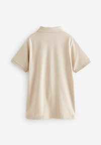 Beige pólóing rövid ujjakkal, klasszikus gallérral és sima textúrával. Nincsenek látható minták vagy fém részletek.