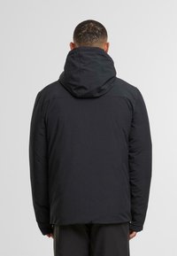 Sort, isoleret jakke med hætte, udstyret med en glat, mat overflade og en afslappet pasform. Inkluderer syningsdetaljer og justerbare manchetter.