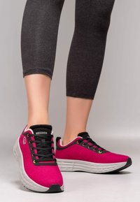 Rosa Sportschuhe aus weichem Stoff mit strukturiertem Finish. Mit schwarzen Schnürsenkeln, weißer Sohle und dezentem Logodetail an der Seite.