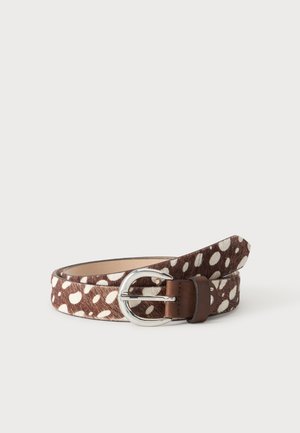 Ceinture en cuir marron et blanc à taches, roulée avec une boucle en métal argenté sur un fond clair uni.