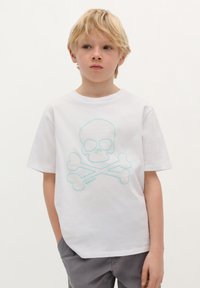 T-shirt bianca in cotone con una grafica di teschio e ossa incrociate azzurro chiaro. Maniche corte, scollatura rotonda, vestibilità rilassata.