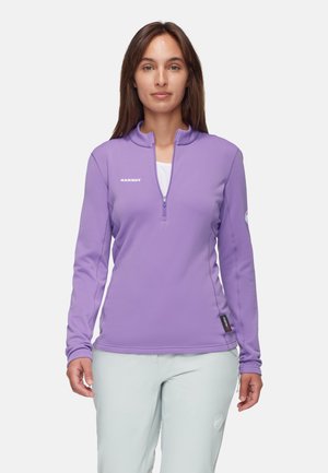 Paarse ritsloze mid-layer fleece met lange mouwen, zachte textuur en logodetail op de borst en mouw. Lichtgewicht voor buitenactiviteiten.