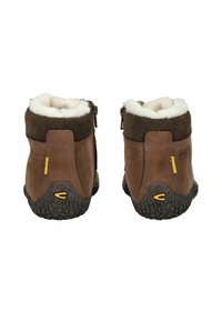 Botas impermeables marrones con un suave forro de piel sintética blanca, parte superior de ante, cremalleras laterales y suelas de goma texturizadas. Acento de logo amarillo en el talón.