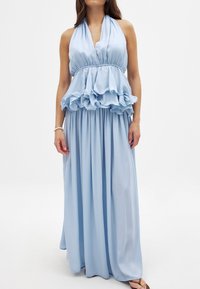 Abito azzurro chiaro con scollo a halter, vita con peplum arricciato e gonna a lunghezza completa, realizzato in tessuto morbido e fluido.