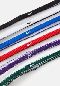 Kolekcia elastických gumičiek na vlasy v čiernej, bielej, modrej, červenej, fialovej a zelenej farbe, s logom Nike na každej gumičke a s rebrovanou textúrou.