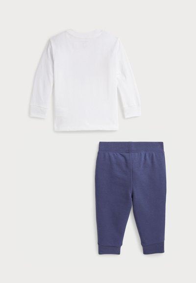Chemise blanche à manches longues avec col rond, en coton ; jogging bleu marine, fuselé avec taille élastique et poignets.