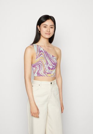 Top cropped de um ombro só com um padrão de espirais coloridas em roxo, amarelo e azul claro, feito de material texturizado; combinado com calças largas em bege.